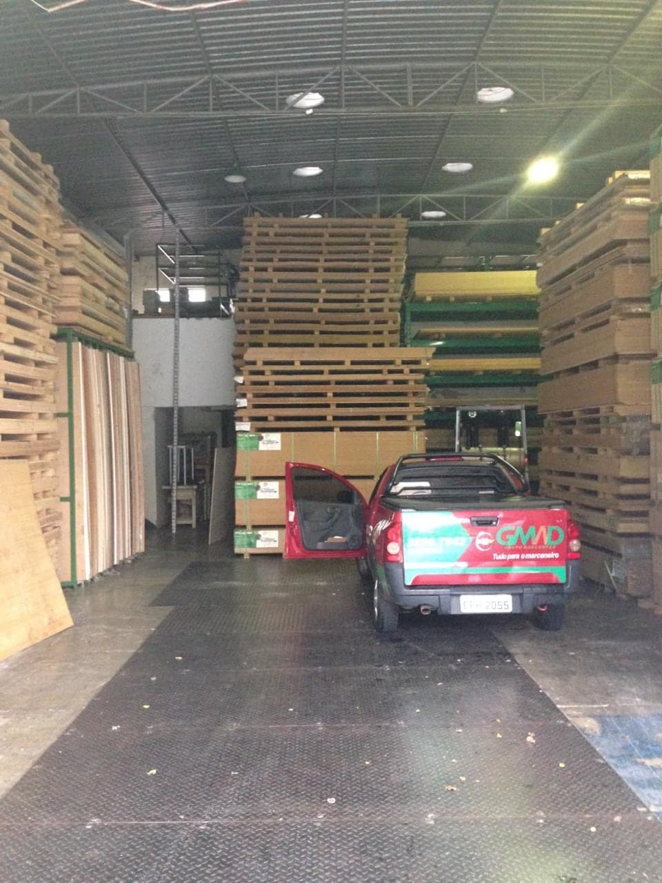 O primeiro barracão do Centro de Serviços, com chapas empilhadas e a picape da loja.